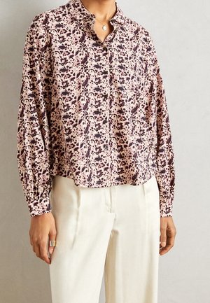 Bluzka z kołnierzykiem w różowo-kremowym kolorze z kwiatowym i abstrakcyjnym wzorem, z długimi rękawami i zapięciem na guziki, wykonana z lekkiego materiału.