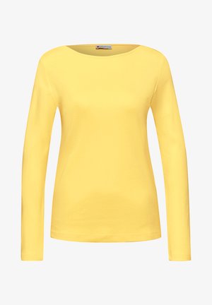 Žlutá dámská košile s dlouhým rukávem, kulatým výstřihem, jednobarevným designem a malou značkovou nášivkou uvnitř límce.