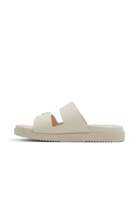 Sandale à glisser beige avec deux brides découpées, semelle plate et fond texturé. Fabriquée en matériau lisse, avec des accents de design minimalistes.