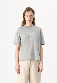 Grey cotton t-shirt with short sleeves, featuring a white logo print "HILFIGER NEW YORK 1985" in the center. Relaxed fit, round neckline.