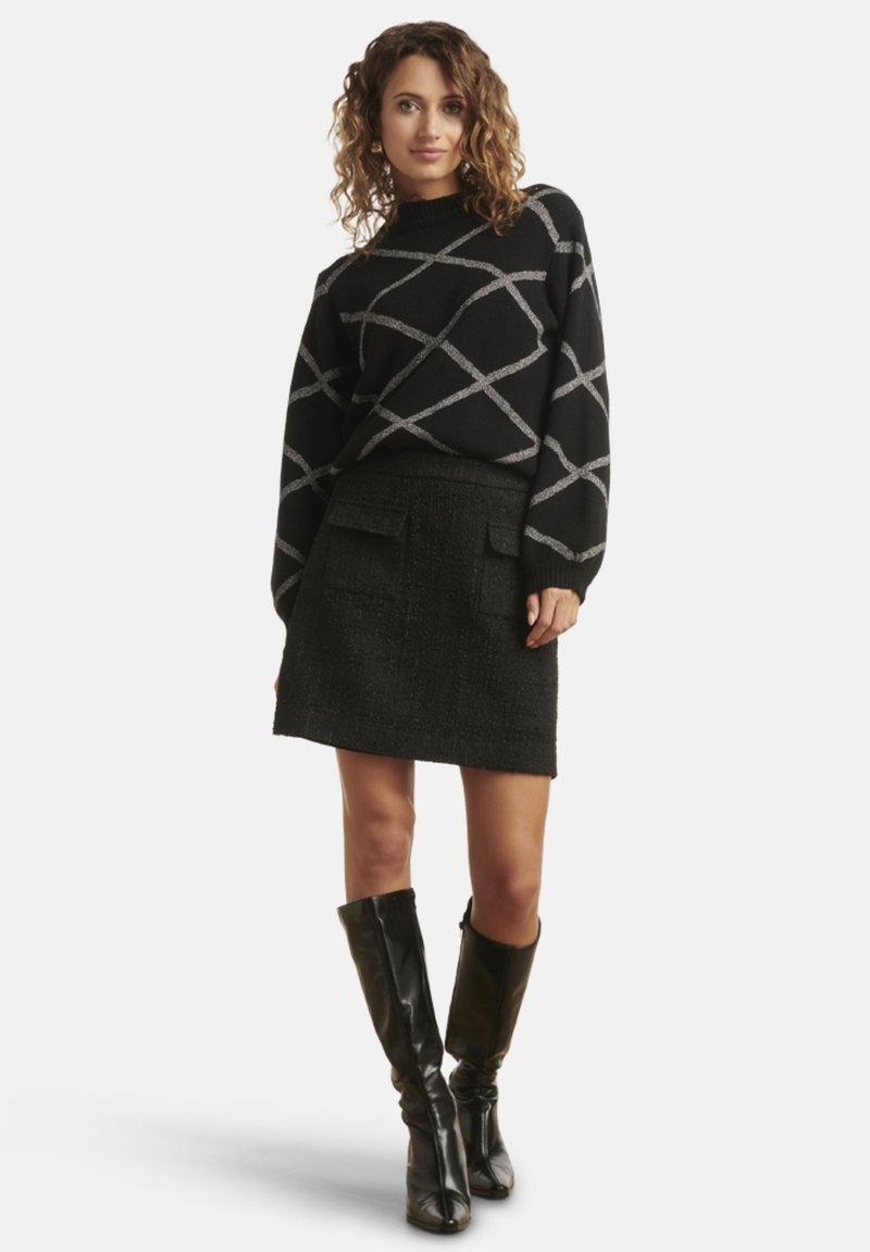 Black sweater with diagonal gray pattern, high neckline; black tweed mini skirt, two pockets; black knee-high boots with fitted style.