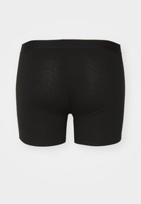 Schwarze Boxershorts aus weichem, dehnbarem Stoff. Mit einem glatten, elastischen Bund. Das Design ist schlicht, ohne Muster oder zusätzliche Akzente.