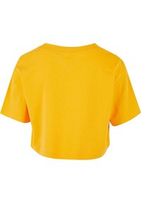 Sárga rövid ujjú crop top póló. Kerek nyakú, sima pamut anyag. Egyszerű dizájn, látható minták vagy fém részletek nélkül.