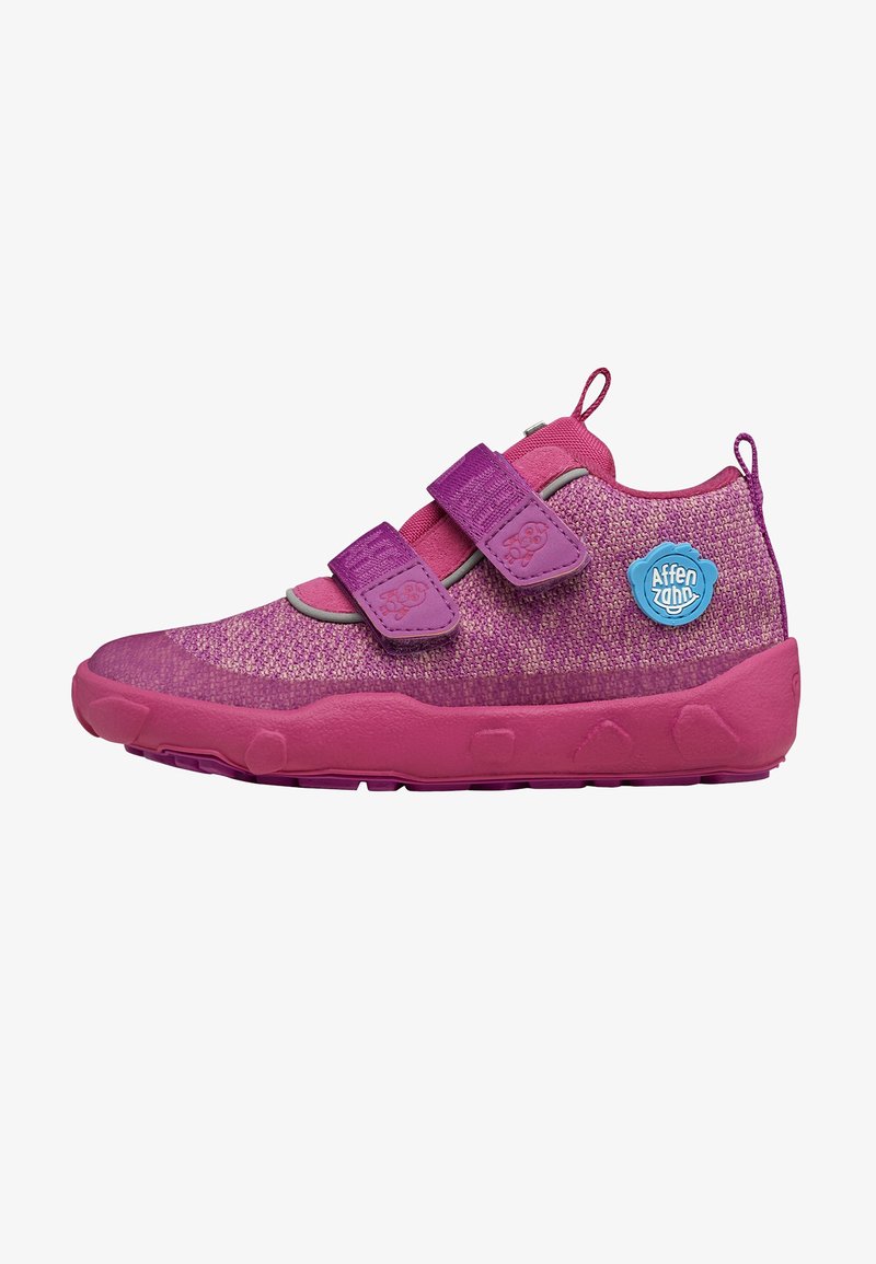 Pink shoes with a textured upper, two purple Velcro straps, and a blue logo. Rounded rubber sole with grip patterns and stitched accents.