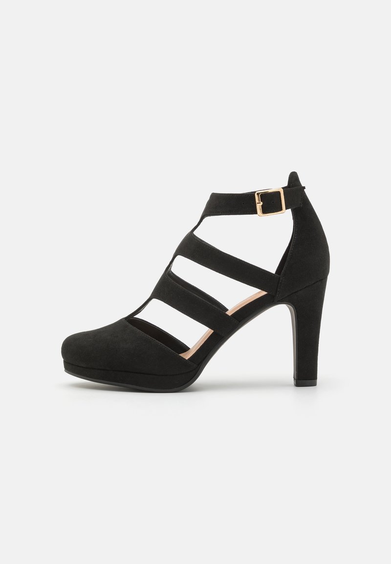Chaussure à talons hauts noire pour femme avec plusieurs brides horizontales et une boucle dorée autour de la cheville, présentée sur un fond blanc.