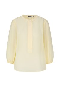 Blusa giallo chiaro con scollo rotondo e placca centrale. Presenta maniche lunghe con polsini elasticizzati e una vestibilità comoda. Tessuto morbido e texturizzato.
