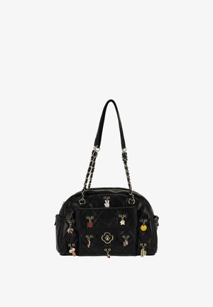Czarna pikowana torebka o zaokrąglonym kształcie, z łańcuszkiem i skórzanymi paskami, ozdobiona wieloma kolorowymi zawieszkami oraz dekoracyjnym emblematem na przodzie.