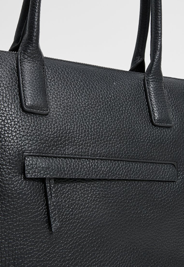 Schwarze Ledertasche mit strukturiertem Oberflächenmaterial, flachen Griffen und einer vorderen Einschubtasche in einem klaren, strukturierten Design.