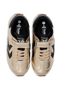 Gold- und schwarze Sportschuhe mit glänzender Oberfläche, ausgestattet mit einem Klettverschluss, Schnürdesign und schwarzem Textilfutter.