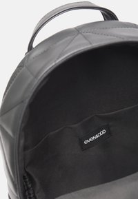 Czarny pikowany plecak z gładką powierzchnią zewnętrzną, podszewką materiałową oraz jedną wewnętrzną kieszenią z metką marki even&odd.