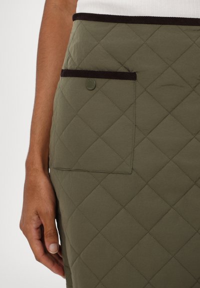 Olivenfarget, quilted skjørt med diamantmønster, med en mørk kordfløyelslinning og en sidelomme med trykknappdetalj.