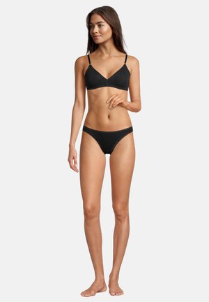 Schwarzes Dessous-Set bestehend aus einem nahtlosen Bralette mit dünnen Trägern und Spitzenakzenten, kombiniert mit passenden low-rise Bikiniunterhosen.