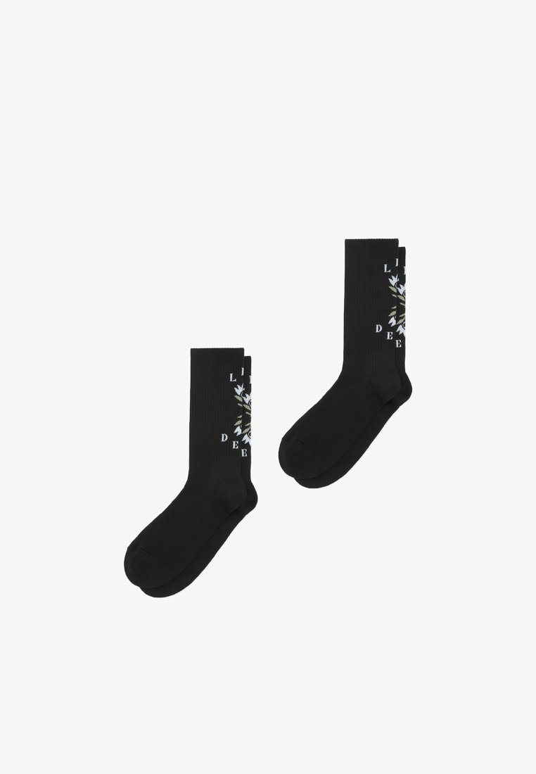 Μαύρες βαμβακερές κάλτσες με ριμπ ύφανση και γραφικό σχέδιο με φύλλα και κείμενο στο πλάι, προσφέροντας άνετη εφαρμογή.