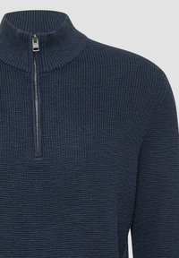 Ciemnoniebieski dzianinowy sweter z wysokim kołnierzem i pół zamkiem. Wykonany z teksturowanej tkaniny w prążkowanym wzorze, co dodaje mu charakteru.