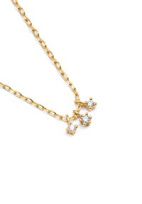 Collier en métal doré à un design en maillons de chaîne, avec trois charms décoratifs sertis de pierres précieuses transparentes. Texture lisse, simple et élégant.