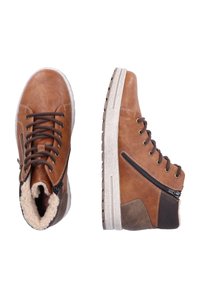 Bottines en cuir marron avec une surface texturée, devant à lacets, accents brun foncé contrastants, fermeture éclair sur le côté et semelle en caoutchouc blanche.