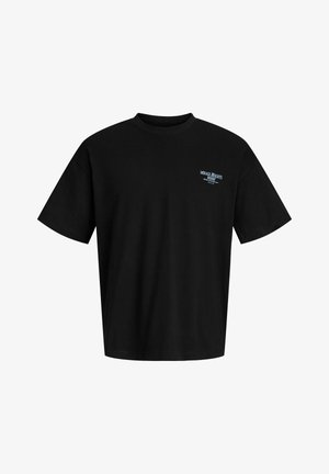 Dreng står iført en lyserød kasket, sort Mirage Heights t-shirt, grå shorts, cremefarvede sokker og beige snørestøvler på en ensfarvet hvid baggrund.