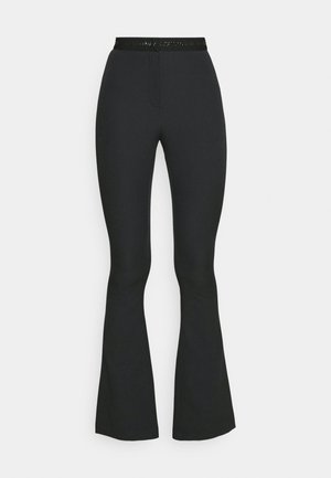Schwarze ausgedehnte Hose aus dehnbarem Material, mit einem flachen Bund und glänzenden Akzenten sowie einem Reißverschluss vorne.