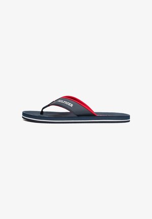 Navy flip-flop with red accents, featuring a textured footbed, thin rubber straps, and white outsole detailing. “HILFIGER” logo on strap.