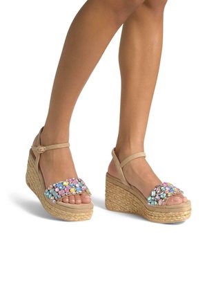 Sandali con zeppa beige con suola in corda intrecciata e una fascia colorata e decorata di gioielli. Caratterizzati da una cinghia alla caviglia regolabile e un design con punta aperta.