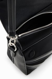 Schwarze Lederhandtasche mit einem Reißverschlussfach, einer strukturierten Oberfläche und einem silbernen Hardware-Akzent an der Gurtbefestigung.