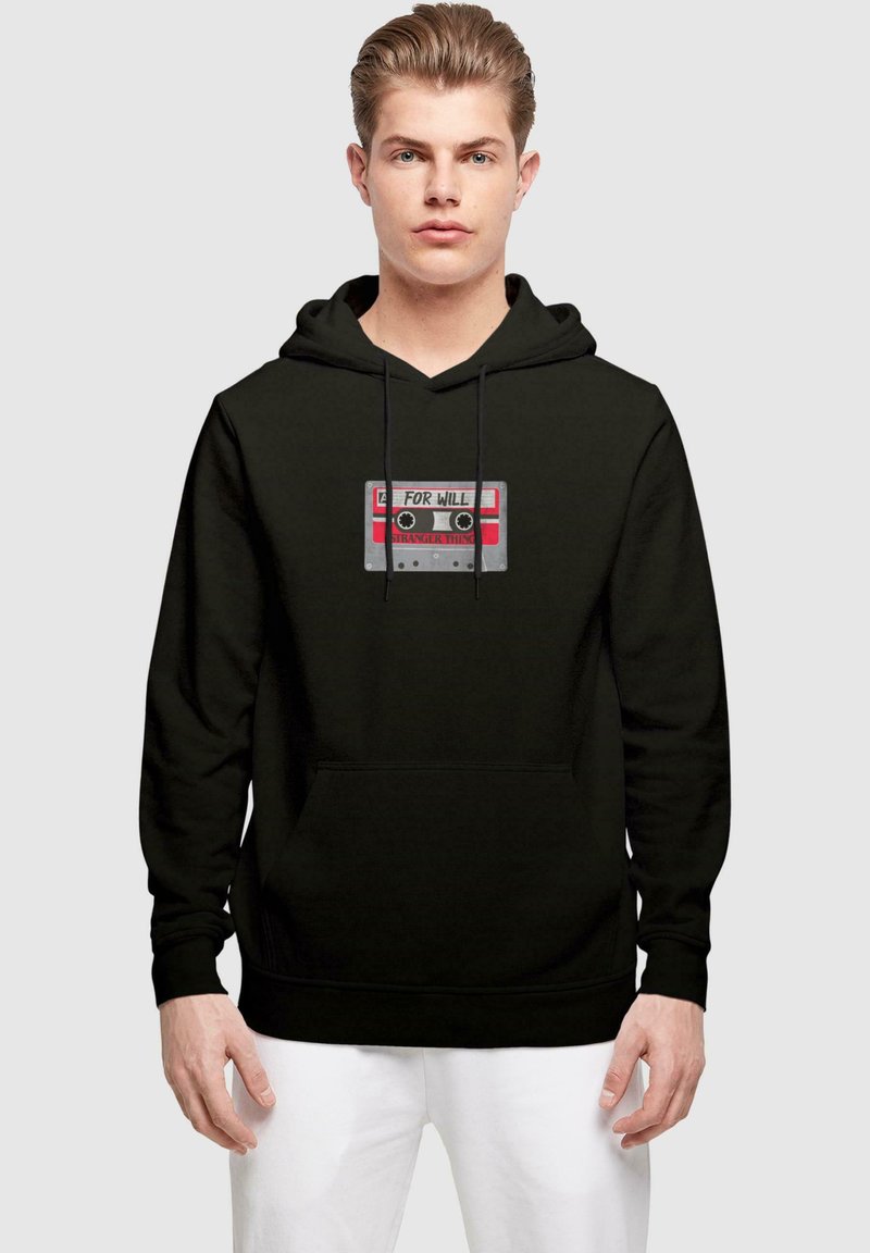 Sudadera negra con un gráfico de una cinta de casete roja y plateada etiquetada con "PARA WILL" y "COSAS EXTRAÑAS" con dos carretes circulares.