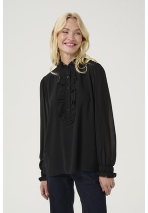 Blusa nera con una pattina frontale arricciata, maniche lunghe con polsini arricciati e un colletto alto realizzato in un tessuto leggero e trasparente.
