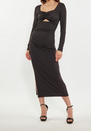 Svart långärmad klänning med en figursydd siluett, rynkad textur, fyrkantig halsringning och en slits i mid-thigh på ena sidan.