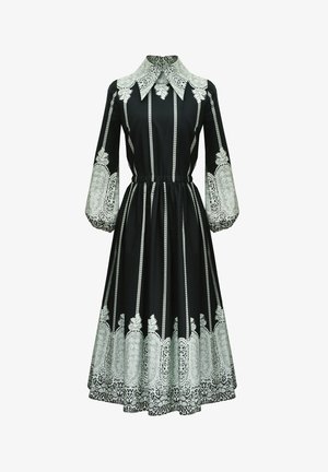 Czarna sukienka z kołnierzykowym dekoltem, długimi rękawami i elastycznym paskiem w talii. Na dole i górnych rękawach znajdują się wymyślne wzory z białej koronki.