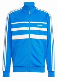 Modrá sportovní bunda Adidas s bílými vodorovnými pruhy přes hruď a třemi bílými pruhy na každém rukávu, s zipem vpředu a bočními kapsami.