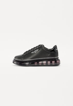 Zapatillas sintéticas negras con un diseño elegante, que cuentan con una suela transparente gruesa y acentos plateados. Cordones con ojetes de metal para mayor durabilidad.