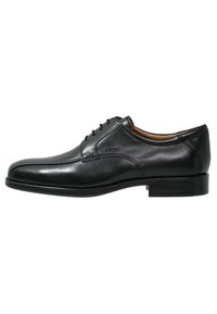 Zapato de vestir de cuero negro con un acabado suave, punta redondeada, seis ojales y un tacón bajo y apilado. Presenta detalles de costura mínimos.