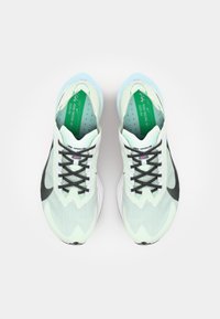 Light green and black running shoes with a textured upper, black laces, and a soft blue sole. Features a distinctive wavy design.