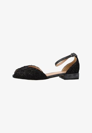 Scarpa da donna nera con tacco basso, tessuto strutturato, cinturino alla caviglia con fibbia e lati aperti su sfondo bianco.