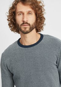 Maglione lavorato a maglia con un motivo testurizzato in blu navy e grigio chiaro. Presenta un collo rotondo e polsini a costine. Tessuto morbido di peso medio.