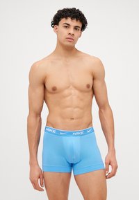 Svetlo modré bavlnené boxerky s bielym logom Nike na páske. Majú priliehavý strih a šev vpredu pre tvar.