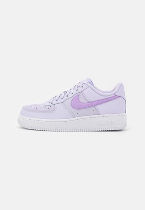 Matalavartinen laventelinvärinen Nike Air Force 1 -tennari, jossa violetti swoosh-logo, rei'itetty varpaan kohdan osa, valkoinen pohja ja nauhat, yksinkertaisella valkoisella taustalla.