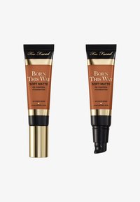 Two tubes of foundation labeled "Born This Way Soft Matte." They are amber-colored with black and gold accents, featuring squeeze tops.