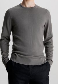 Grauer Langarmpullover aus weichem Strickstoff mit Rundhalsausschnitt, gerippten Bündchen und Saum sowie schlanker Passform.