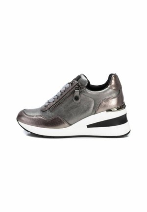 Zapatilla metálica gris con un acabado texturizado, que presenta un cierre lateral, cordones grises y un diseño de suela cuña en blanco y negro.