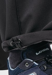 Blauer Textil-Sneaker mit schwarzem Zubehör und Schnürsenkeln, kombiniert mit einem schwarzen Stoffbund mit Kordelzugverstellung.