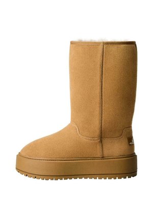 Tan mockasinför ankle boots med rund tå, mjukt foder och en robust gummiyttersula. Har minimal sömnad och en logotypdetalj.