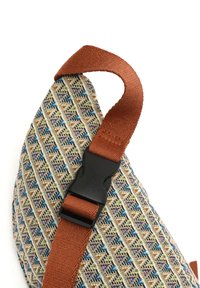 Borsa in tessuto con una stoffa a motivo nei colori crema, blu e verde. Presenta una tracolla marrone e una fibbia in plastica nera. Forma triangolare distintiva.