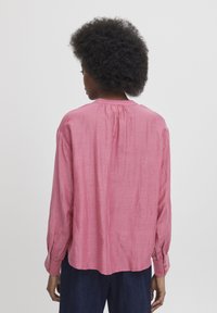 Camicia a maniche lunghe rosa realizzata in tessuto leggero, con yoke sul retro, polsini abbottonati e vestibilità rilassata. Tessuto morbido.
