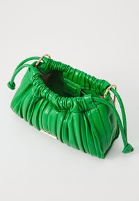 Green leather handbag with gathered texture, gold hardware, and drawstring closure. Compact shape with a smooth finish and subtle sheen.