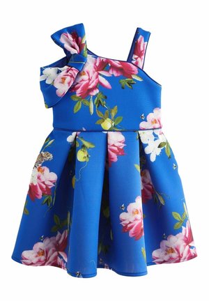 Robe bleue sans manches avec imprimé floral rose et blanc, feuilles vertes, jupe plissée et grand nœud sur une épaule.