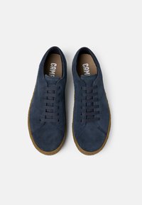 Navy suede sneakers with a rounded toe, eight eyelets, and brown rubber sole. Features understated stitching and "CAMBRIDGE" branding inside.