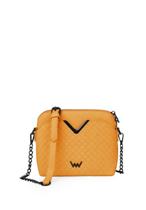 Padded oranžová kabelka s černým řetízkovým popruhem, která se vyznačuje elegantním designem a černým akcentem ve tvaru V na přední straně.