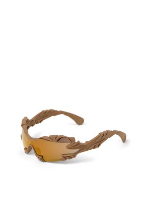 Brązowe okulary przeciwsłoneczne z rzeźbionymi oprawkami o fakturze przypominającej liście oraz zakrzywionymi soczewkami o bursztynowym odcieniu, przedstawione na białym tle.