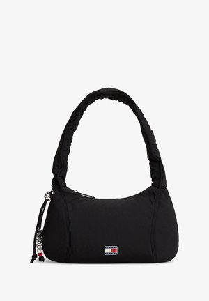 Sort nylon skuldertaske med en blød, polstret rem, lynlås, logo-patch og dekorative snøredetaljer. Glat tekstur og rundet form.